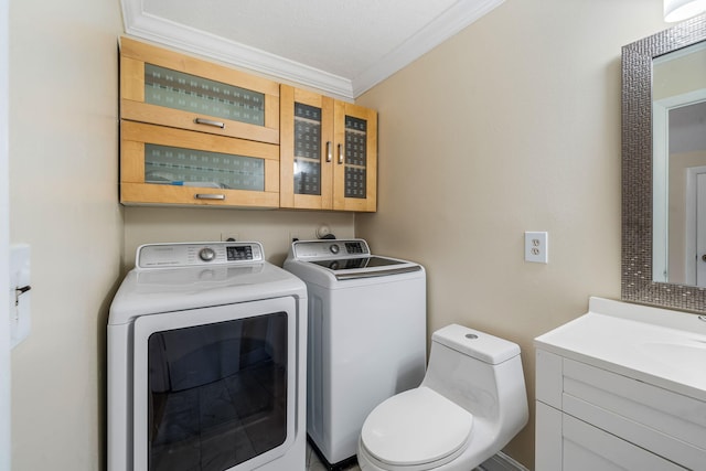 half bathroom with toilet, vanity, ornamental molding, and washer and dryer