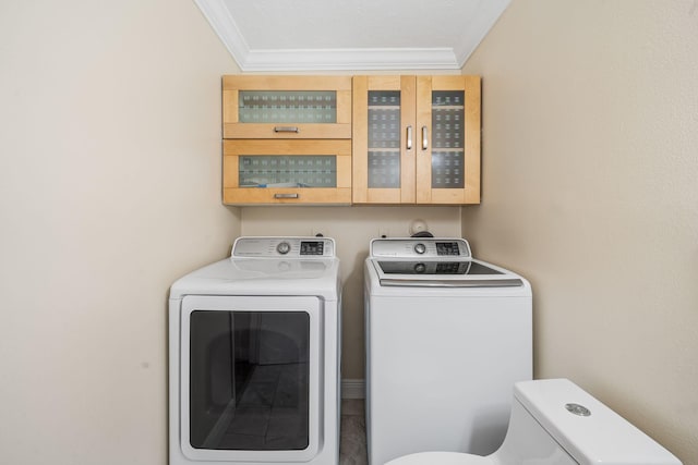 laundry room with washing machine and dryer and ornamental molding