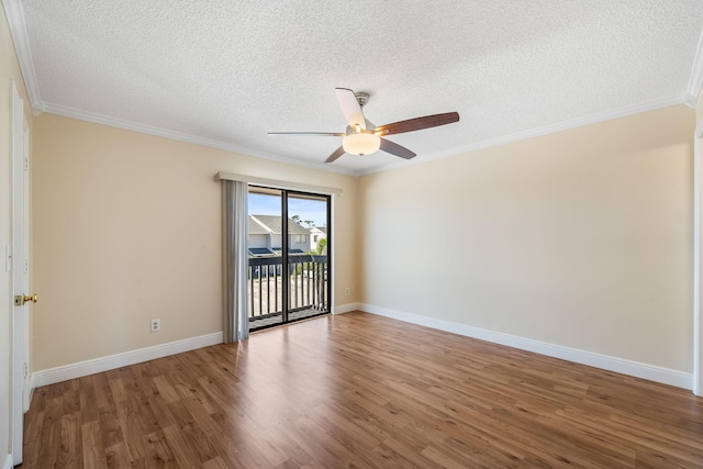 empty room with a textured ceiling, crown molding, baseboards, wood finished floors, and a ceiling fan