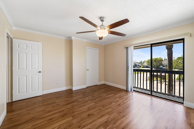 empty room with a textured ceiling, ceiling fan, wood finished floors, and ornamental molding