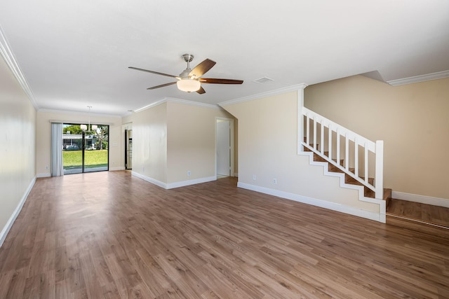 unfurnished living room featuring wood finished floors, baseboards, stairway, and visible vents