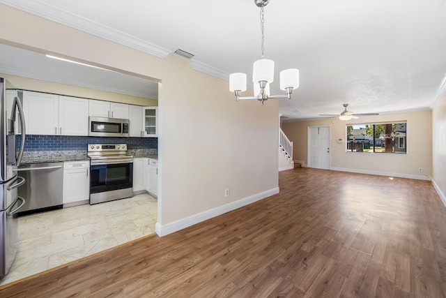kitchen with white cabinets, visible vents, appliances with stainless steel finishes, open floor plan, and backsplash
