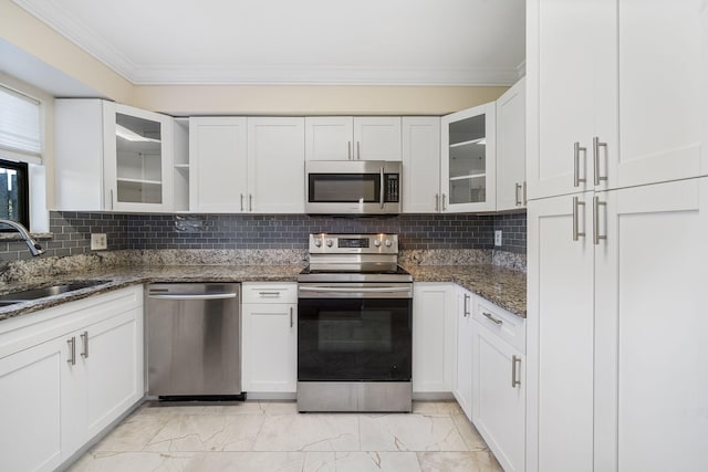 kitchen with white cabinetry, ornamental molding, marble finish floor, a sink, and appliances with stainless steel finishes