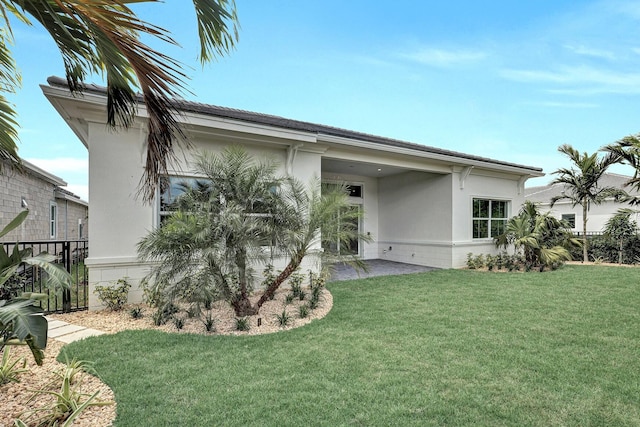 back of property featuring stucco siding and a yard