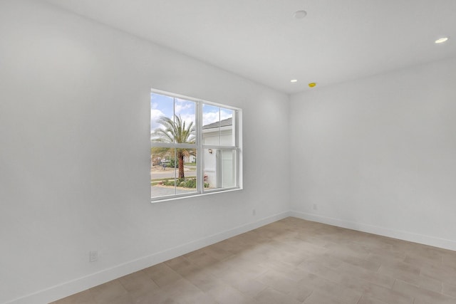 unfurnished room with baseboards, recessed lighting, and light floors