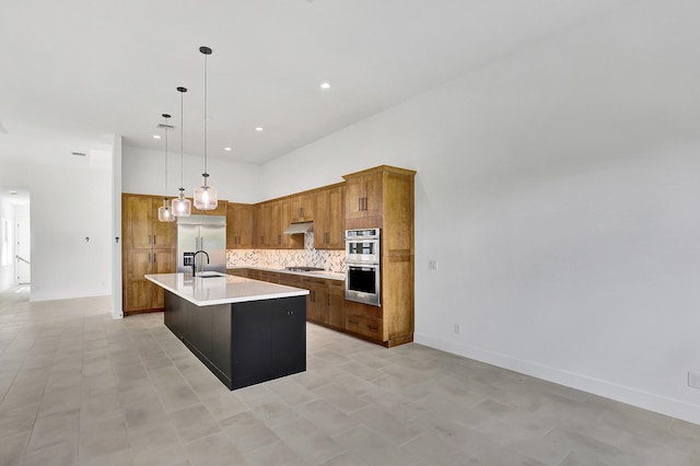 kitchen with appliances with stainless steel finishes, tasteful backsplash, brown cabinets, a sink, and light countertops