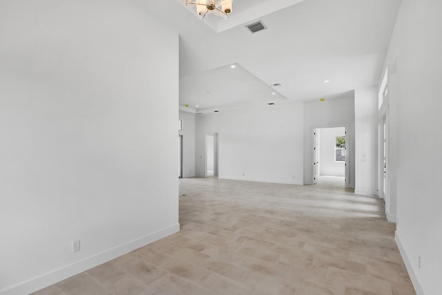 empty room with recessed lighting, a high ceiling, visible vents, and baseboards