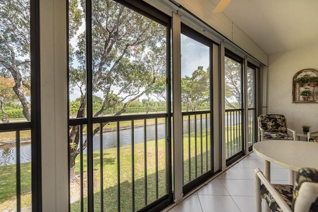 sunroom / solarium featuring a water view