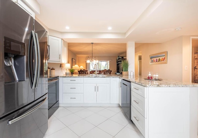 kitchen featuring light stone counters, a sink, pendant lighting, appliances with stainless steel finishes, and white cabinets