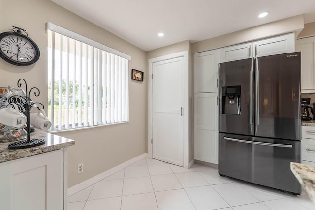 kitchen featuring stainless steel fridge, light stone countertops, light tile patterned flooring, and recessed lighting