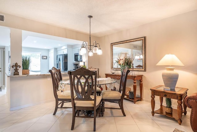 dining room featuring light tile patterned floors, a textured ceiling, baseboards, and visible vents