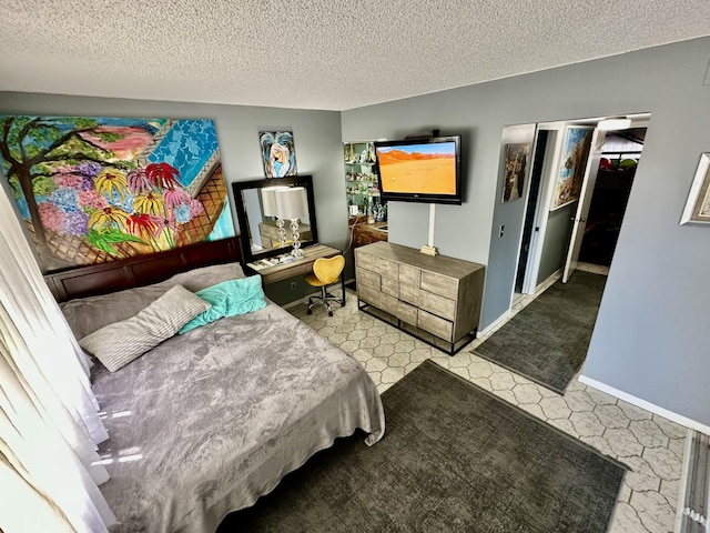 bedroom featuring tile patterned floors, baseboards, and a textured ceiling