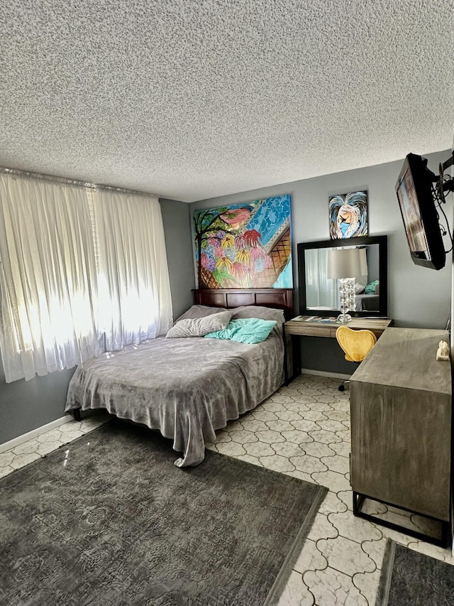 bedroom with a textured ceiling and baseboards