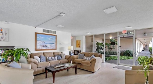 living room with expansive windows, visible vents, and a textured ceiling