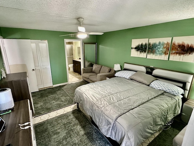 bedroom with carpet floors, ceiling fan, ensuite bathroom, and a textured ceiling