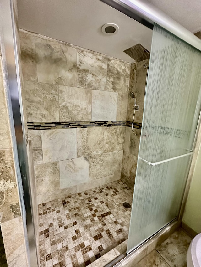 bathroom featuring a shower stall and toilet