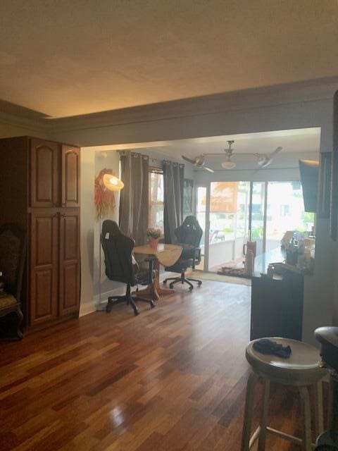 living area featuring wood finished floors and crown molding