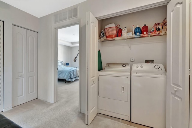2061 SE Glen Ridge Dr, Port Saint Lucie, FL 34952 - washroom featuring washing machine and clothes dryer, light carpet, laundry area, baseboards, and visible vents