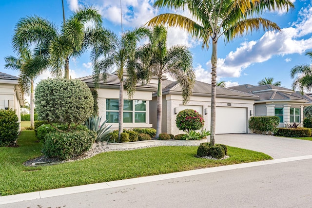 9237 Seahorse Bay Dr, Boynton Beach, FL 33473 - view of front of property with decorative driveway, an attached garage, a front yard, a tile roof, and stucco siding