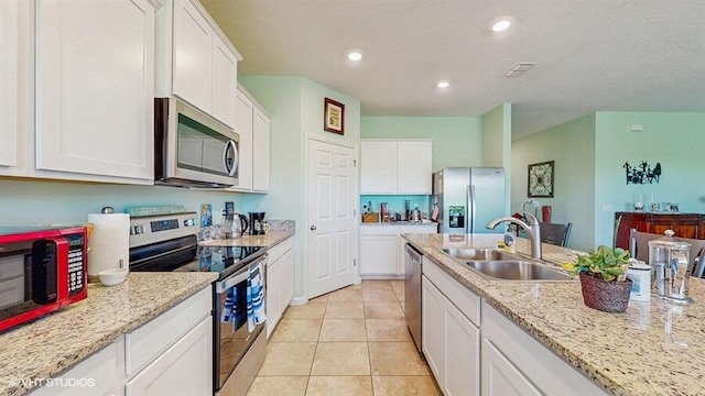 10577 SW Toren Way, Port Saint Lucie, FL 34987 - kitchen featuring stainless steel appliances, a sink, white cabinets, light tile patterned floors, and recessed lighting