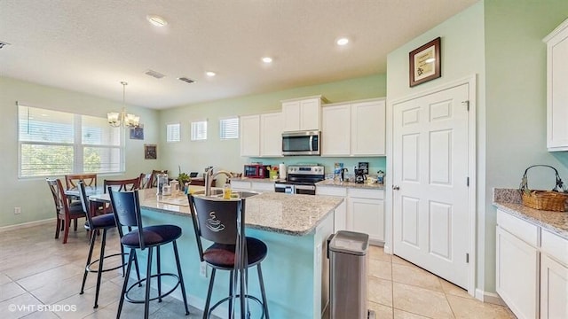10577 SW Toren Way, Port Saint Lucie, FL 34987 - kitchen featuring appliances with stainless steel finishes, a chandelier, healthy amount of natural light, a kitchen breakfast bar, and recessed lighting
