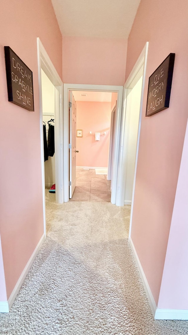 hall featuring baseboards and carpet