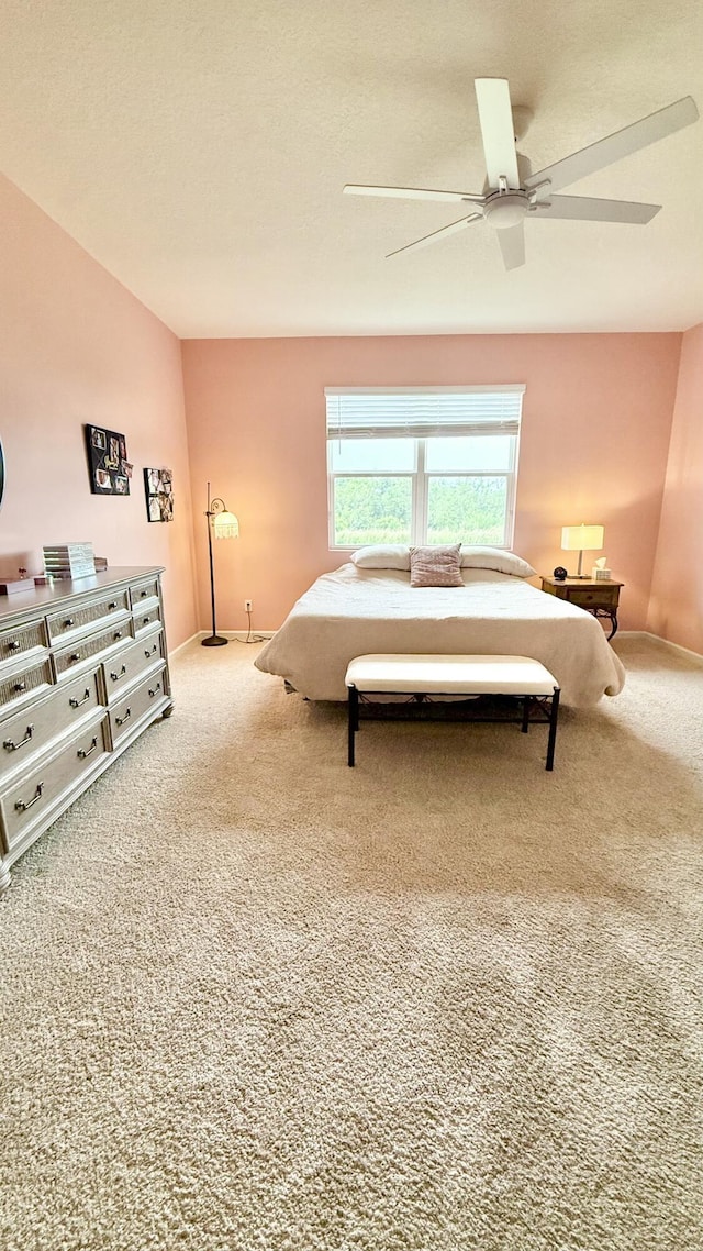 carpeted bedroom featuring a textured ceiling and a ceiling fan