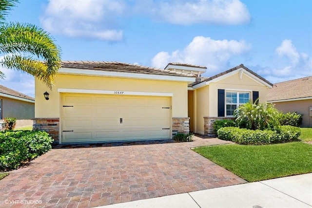 10577 SW Toren Way, Port Saint Lucie, FL 34987 - view of front of home featuring stone siding, stucco siding, a tile roof, and an attached garage