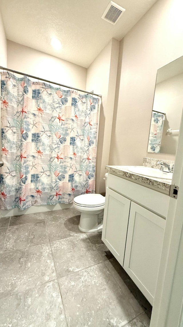 bathroom with visible vents, toilet, and vanity