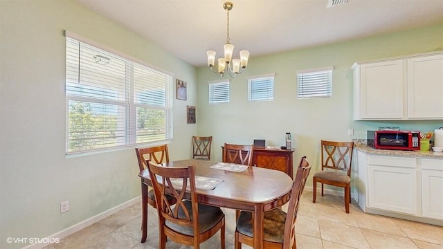 10577 SW Toren Way, Port Saint Lucie, FL 34987 - dining area with a chandelier, light tile patterned floors, and baseboards