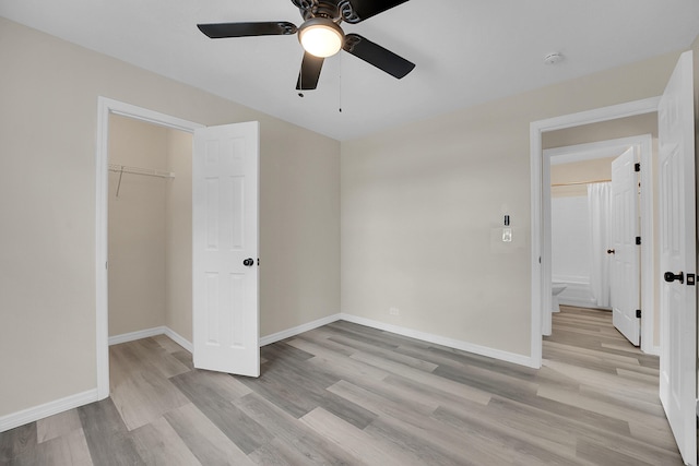 1701 SE Floresta Dr, Port Saint Lucie, FL 34983 - unfurnished bedroom with light wood-style floors, baseboards, a closet, a ceiling fan, and a walk in closet
