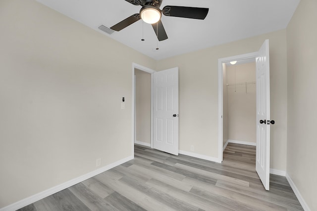 1701 SE Floresta Dr, Port Saint Lucie, FL 34983 - unfurnished bedroom featuring light wood-style floors, a closet, baseboards, a ceiling fan, and a spacious closet