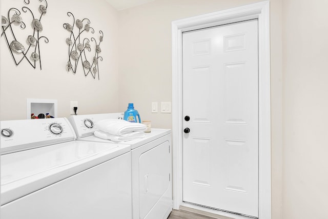 1701 SE Floresta Dr, Port Saint Lucie, FL 34983 - laundry room featuring washer and clothes dryer and light wood-style flooring