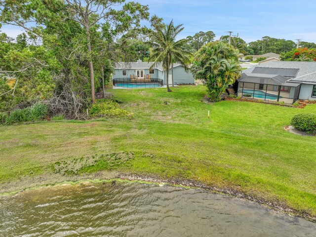 1701 SE Floresta Dr, Port Saint Lucie, FL 34983 - view of grassy yard with an outdoor pool and glass enclosure
