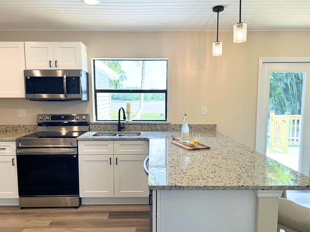 1701 SE Floresta Dr, Port Saint Lucie, FL 34983 - kitchen with appliances with stainless steel finishes, a sink, a peninsula, and healthy amount of natural light