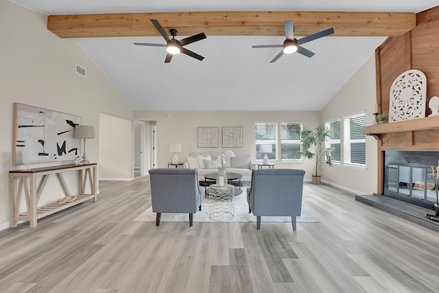 1701 SE Floresta Dr, Port Saint Lucie, FL 34983 - living area with high vaulted ceiling, a ceiling fan, baseboards, a glass covered fireplace, and light wood-style floors
