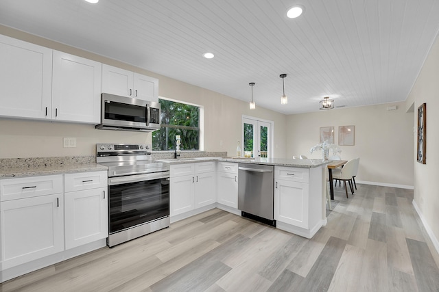 1701 SE Floresta Dr, Port Saint Lucie, FL 34983 - kitchen featuring appliances with stainless steel finishes, a peninsula, white cabinetry, wooden ceiling, and a sink