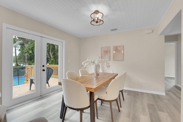 1701 SE Floresta Dr, Port Saint Lucie, FL 34983 - dining area featuring french doors, a chandelier, light wood finished floors, and baseboards