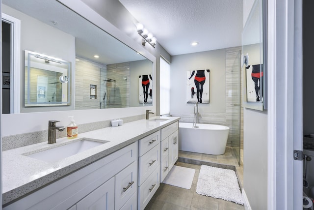 full bath featuring a stall shower, double vanity, a soaking tub, a textured ceiling, and recessed lighting