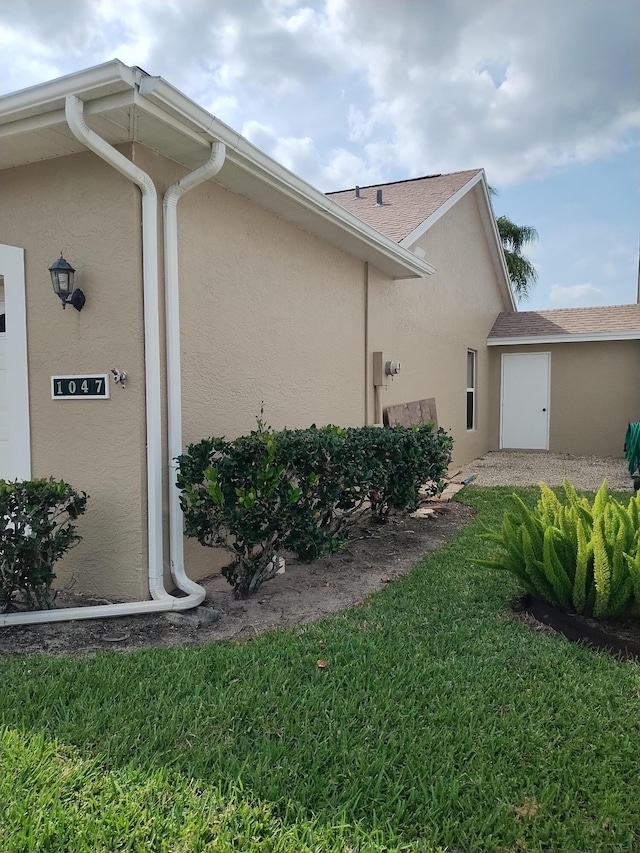 1047 NW Tuscany Dr, Port Saint Lucie, FL 34986 - view of home's exterior featuring stucco siding and a yard