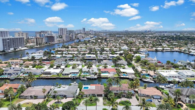 aerial view of property and surrounding area with a large body of water, nearby urban area, and nearby suburban area