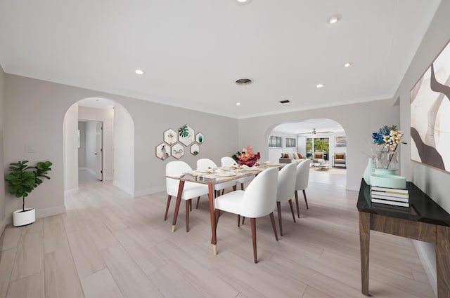 dining space featuring arched walkways, baseboards, and recessed lighting