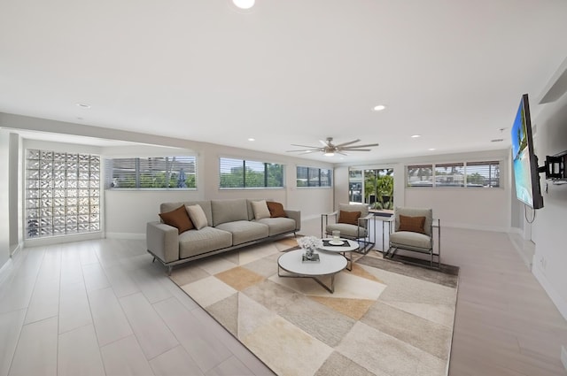 living room featuring a ceiling fan, baseboards, and recessed lighting