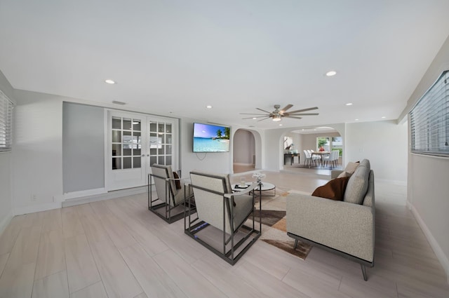 living area with arched walkways, french doors, baseboards, a ceiling fan, and recessed lighting