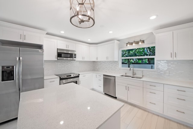 kitchen with stainless steel appliances, a sink, white cabinetry, recessed lighting, and a chandelier