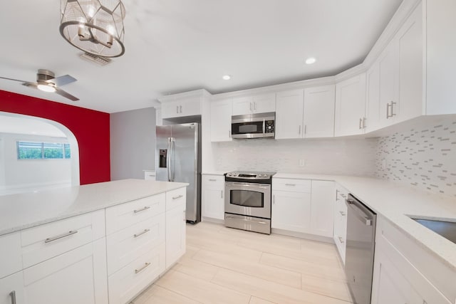 kitchen with stainless steel appliances, light countertops, tasteful backsplash, white cabinets, and recessed lighting