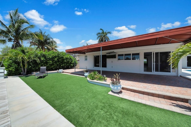 back of property with a patio and a lawn