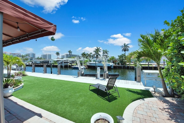 dock featuring a water view, a lawn, and boat lift