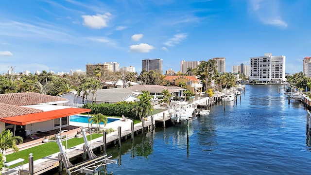 water view with a dock, boat lift, and nearby urban area