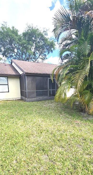163 Pinto Palm Ct Unit 02, Royal Palm Beach, FL 33411 - back of house featuring a sunroom, a lawn, and a shingled roof